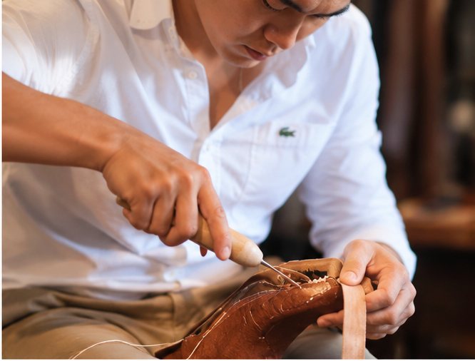 Close view of Bell's hands working on a shoe