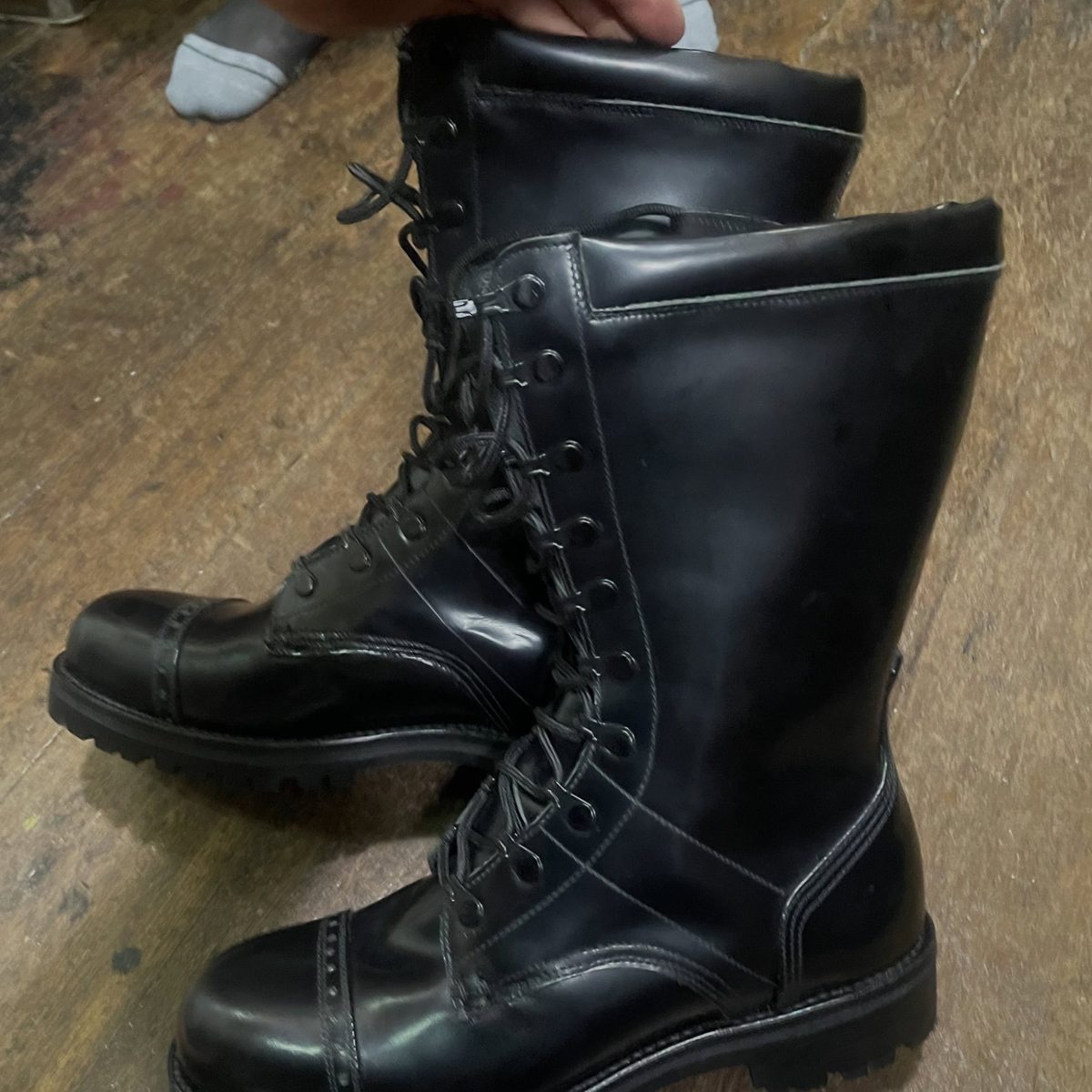 Black cap-toe lace-up boots on a lugged sole