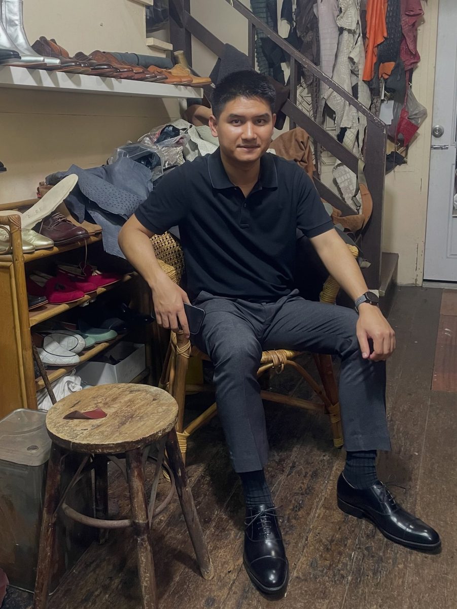 In the atelier, in black cap-toe oxfords