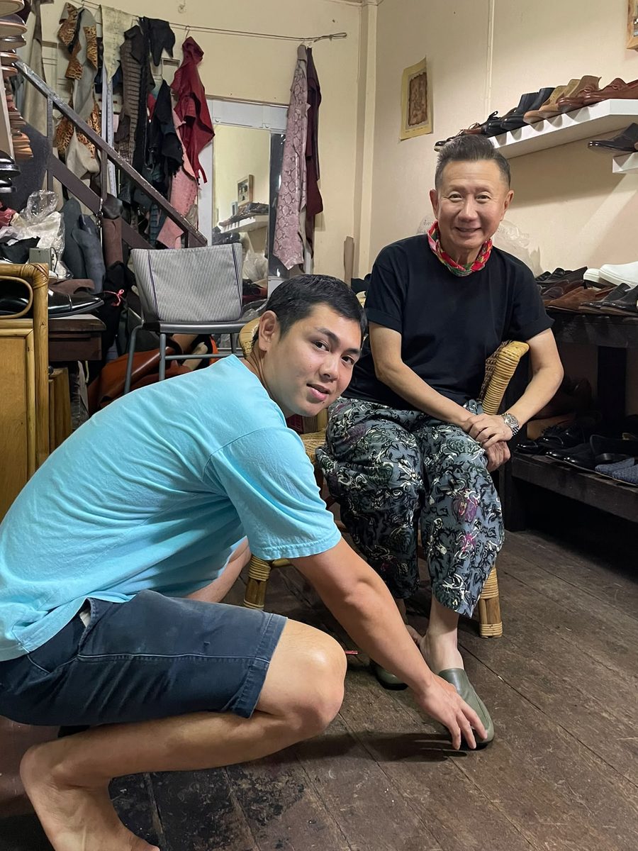 Bell checking the fit of a client's new slippers